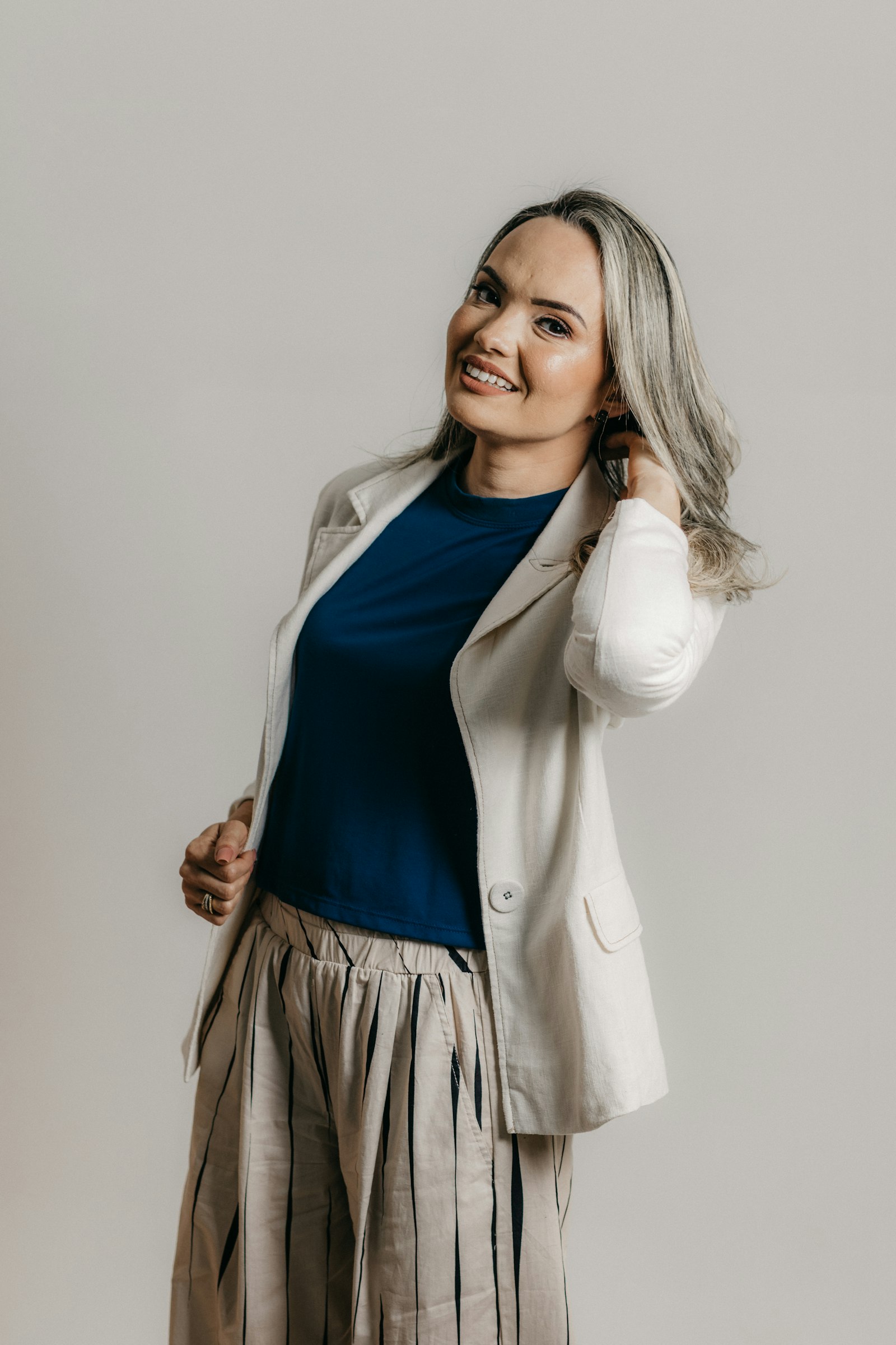Navy top with a cream blazer and cream linen trousers