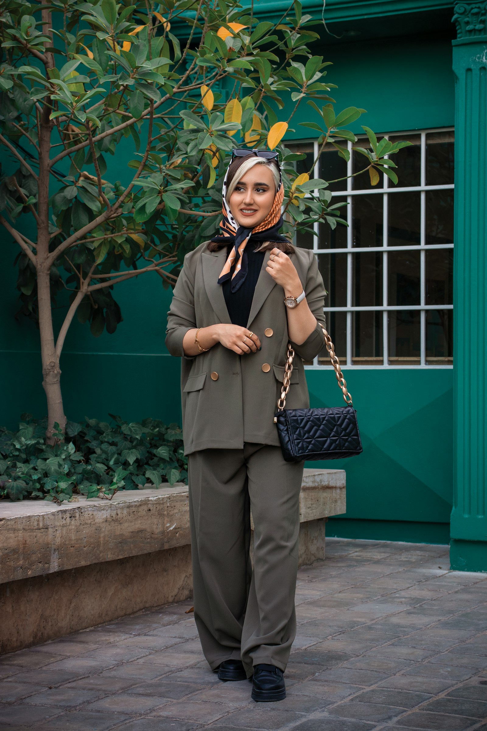 Olive green suit with a black bag: olive worn as a neutral