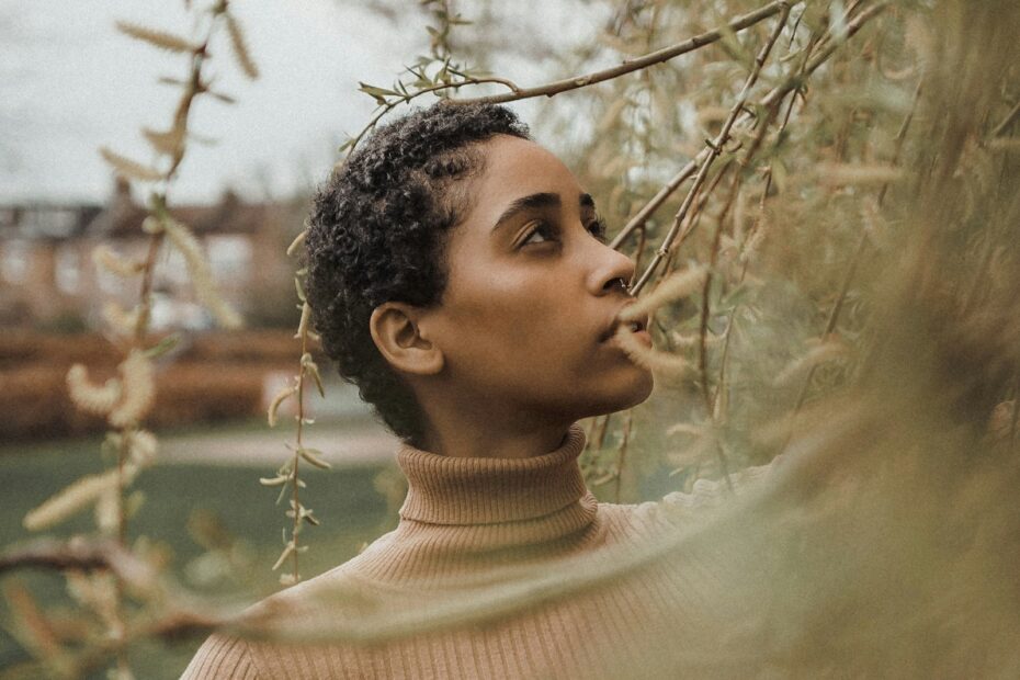 Woman with warm golden-brown skin wearing a camel ribbed turtleneck