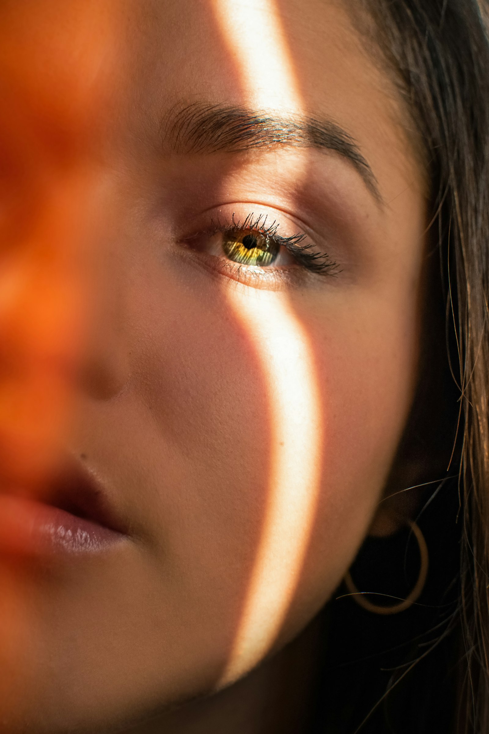 Close-up of warm skin and a gold earring in golden light